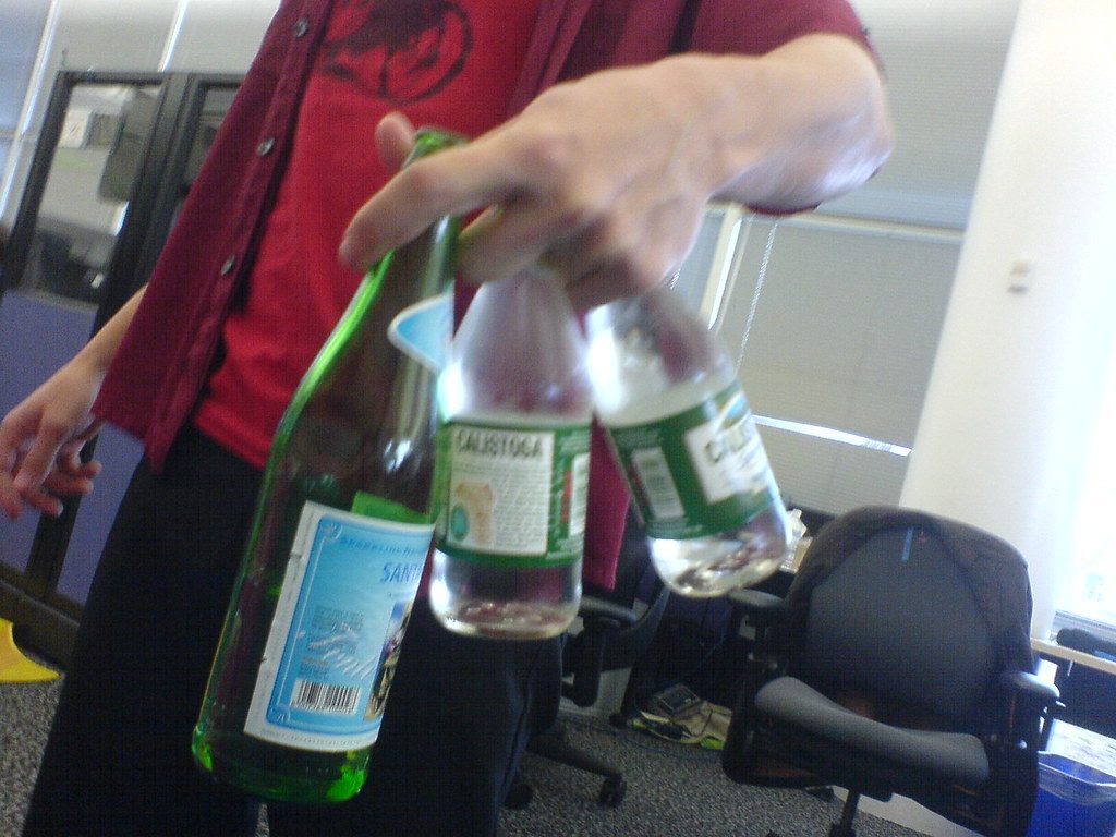 A hand holding a glass of sparkling water